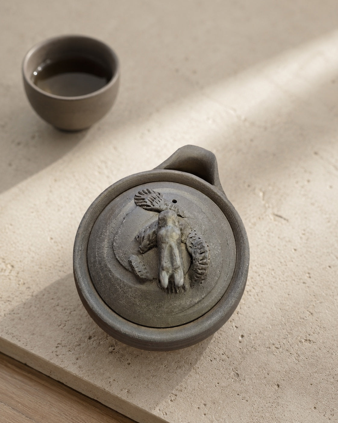 Detail of hand-modelled dragon finial, scales cut individually in dark clay.