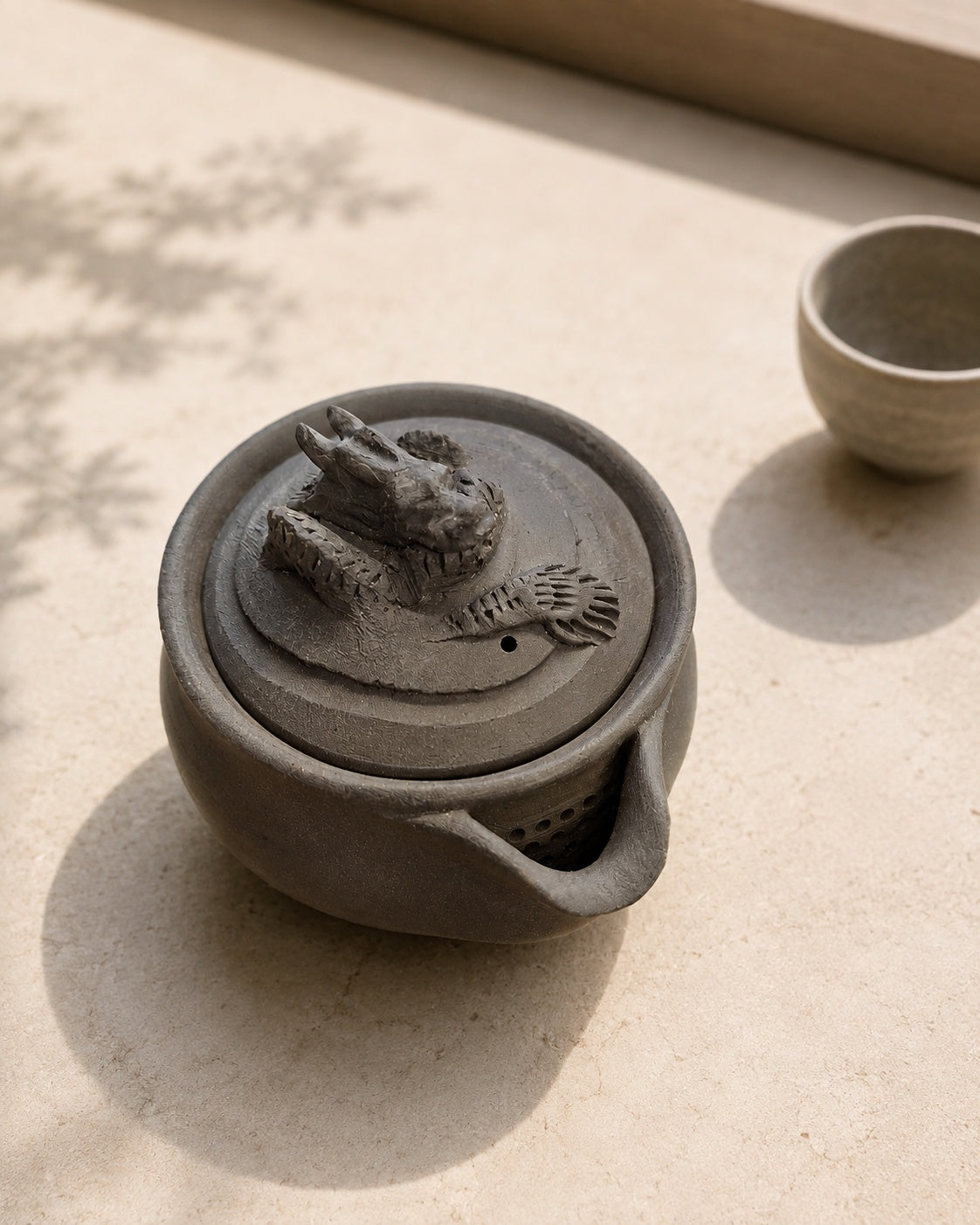 Hōhin seen from above on stone, lid on, pierced strainer visible below lip.