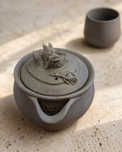 Side view of unglazed hōhin showing wide pour lip and pierced integral strainer.